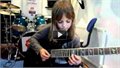 ילדה קטנה מאוד כישרונית מנגנת על גיטרה